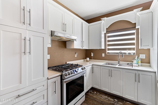 kitchen with under cabinet range hood, a sink, white cabinets, light countertops, and stainless steel range with gas stovetop