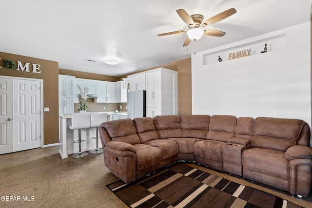 living area with visible vents, a ceiling fan, and speckled floor