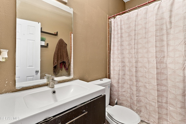 bathroom featuring curtained shower, toilet, vanity, and a textured wall