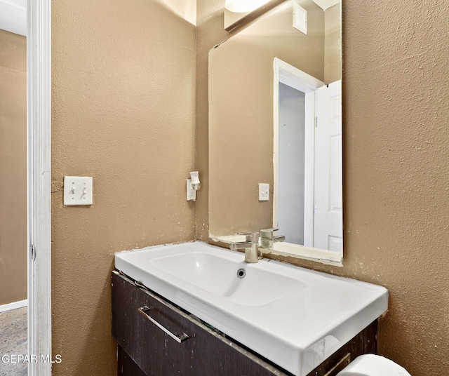 bathroom featuring vanity and a textured wall