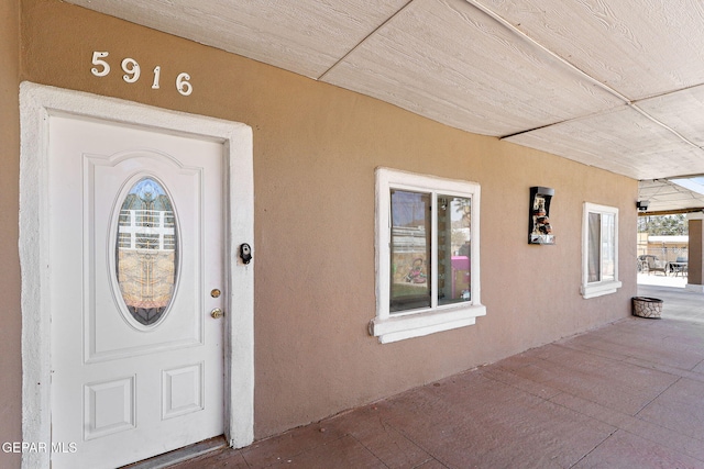 entrance to property featuring stucco siding