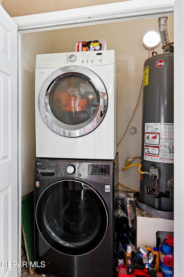 washroom featuring water heater, laundry area, and stacked washing maching and dryer