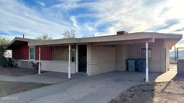 view of front of property featuring a carport, concrete driveway, and brick siding