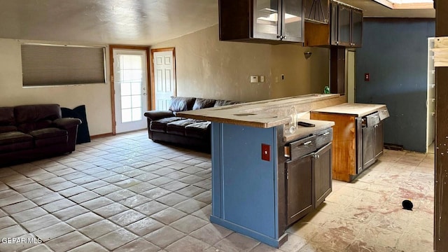 kitchen with vaulted ceiling, glass insert cabinets, and open floor plan