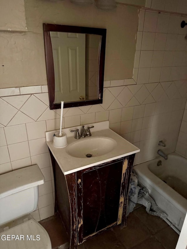 bathroom with toilet, backsplash, tile walls, shower / bath combination, and vanity