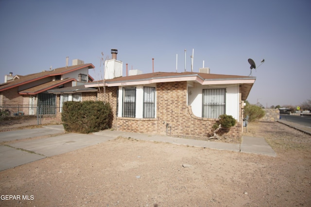 view of front of house with brick siding and fence