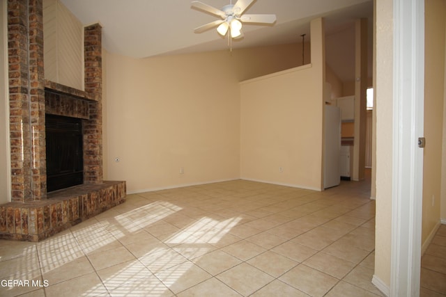 unfurnished living room featuring lofted ceiling, a brick fireplace, light tile patterned floors, and a ceiling fan