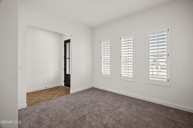 unfurnished room with carpet flooring and baseboards
