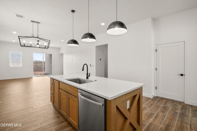 kitchen with dishwasher, wood finish floors, visible vents, and a sink