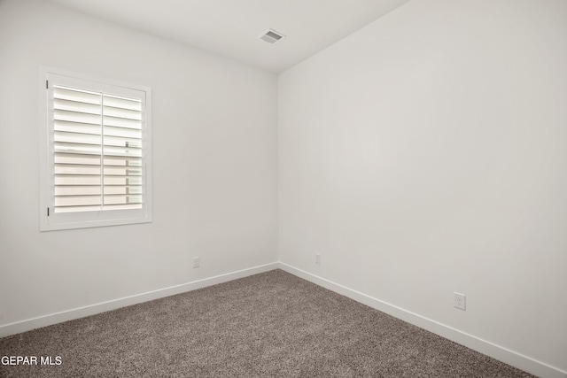 carpeted empty room featuring baseboards and visible vents