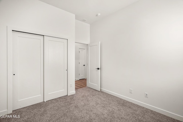 unfurnished bedroom featuring carpet, a closet, and baseboards