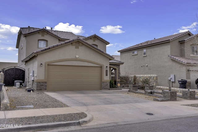 mediterranean / spanish-style home with a garage, stone siding, driveway, and stucco siding