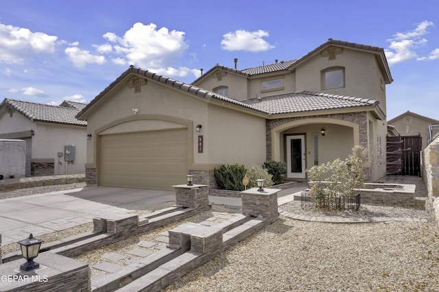 mediterranean / spanish-style home featuring stucco siding, concrete driveway, and an attached garage