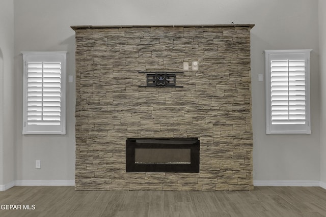 interior details featuring wood finish floors, baseboards, and a fireplace