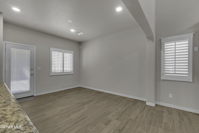 unfurnished room featuring recessed lighting, baseboards, and wood finished floors