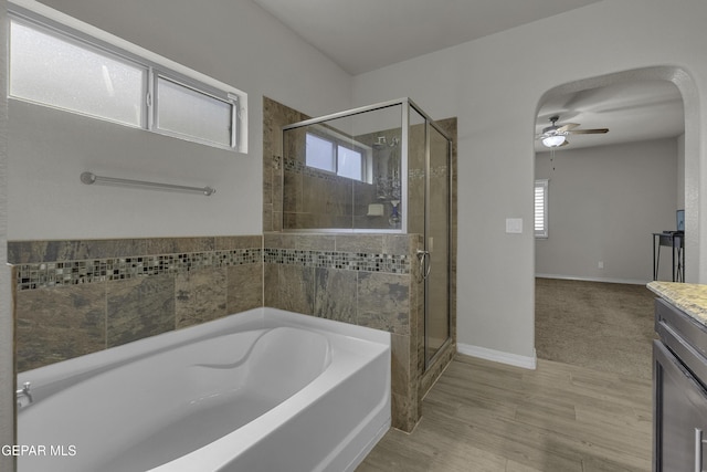 full bathroom featuring a stall shower, vanity, a garden tub, and a ceiling fan