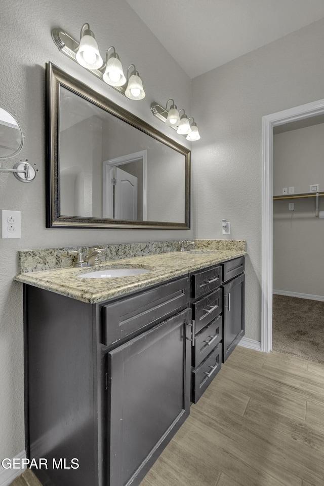 full bathroom with vanity, baseboards, and wood finished floors