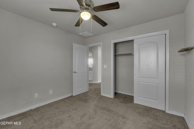 unfurnished bedroom with a closet, ceiling fan, baseboards, and carpet