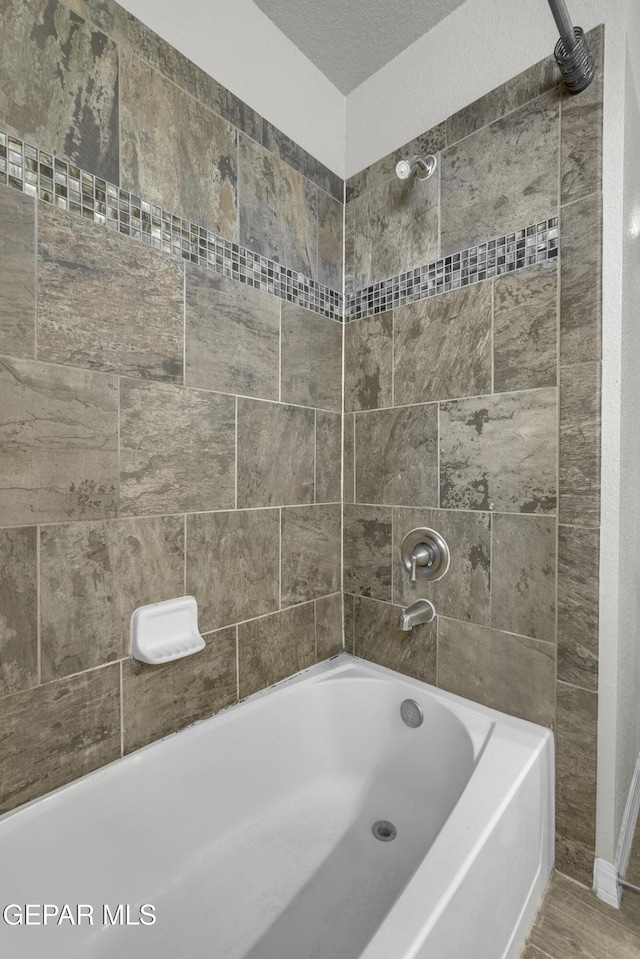 full bath featuring shower / washtub combination and wood finished floors