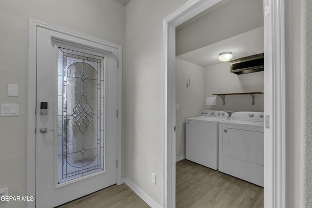 entrance foyer with light wood-style flooring, baseboards, and washing machine and clothes dryer