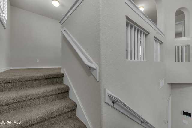 stairs featuring carpet flooring and baseboards