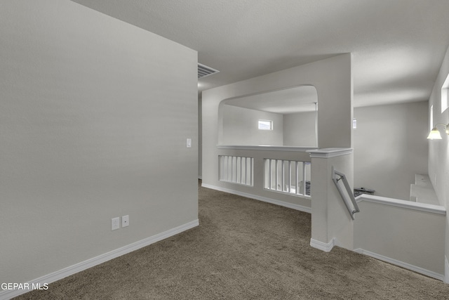 carpeted empty room featuring visible vents and baseboards