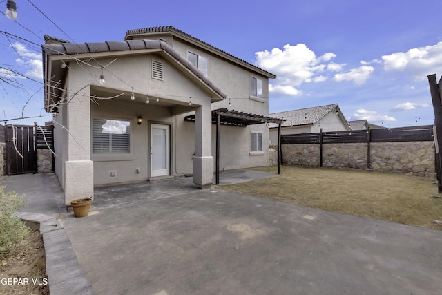 back of house featuring a patio, fence, a pergola, stucco siding, and a tiled roof