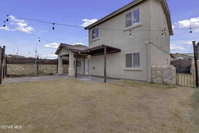 rear view of property with a patio area, a tile roof, fence, and a gate