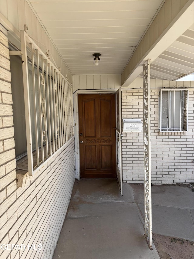 entrance to property featuring brick siding