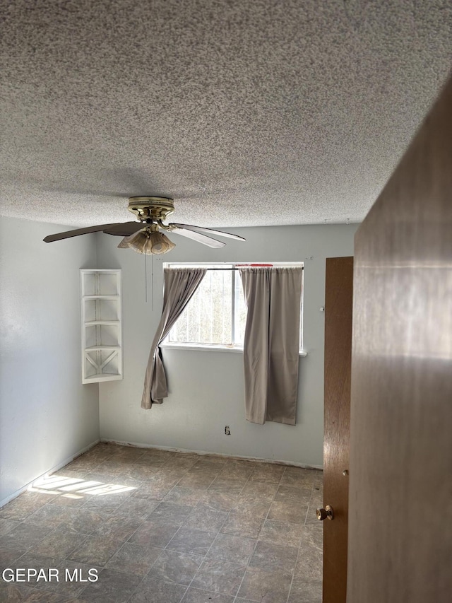 spare room featuring a textured ceiling and ceiling fan