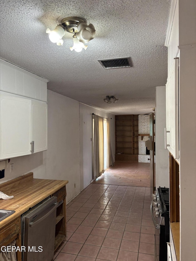 kitchen with visible vents, stainless steel dishwasher, range with gas cooktop, white cabinets, and light tile patterned floors