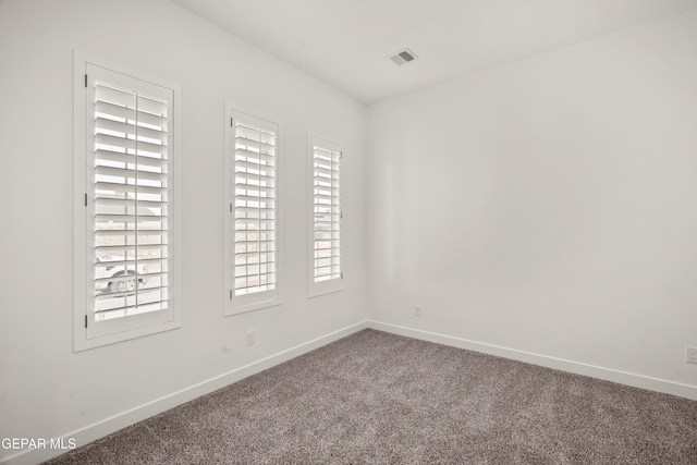 carpeted empty room featuring visible vents and baseboards