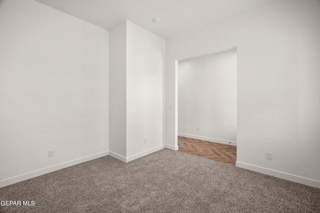 empty room featuring carpet and baseboards