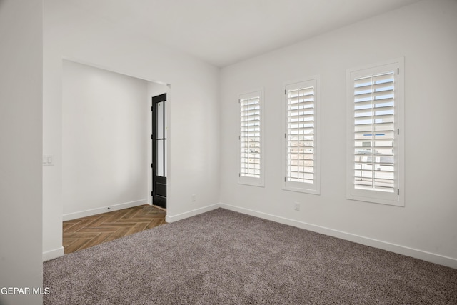 carpeted spare room featuring baseboards