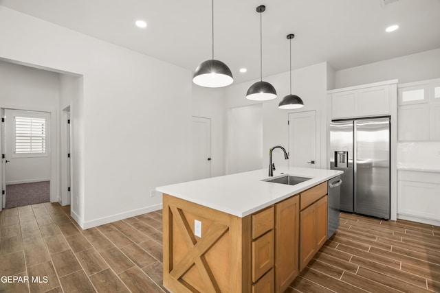 kitchen featuring wood tiled floor, recessed lighting, a sink, stainless steel appliances, and pendant lighting