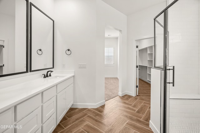 full bathroom with a shower stall, vanity, and baseboards