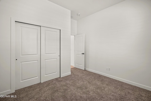 unfurnished bedroom with a closet, baseboards, and carpet