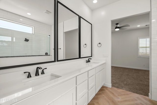 full bathroom with visible vents, recessed lighting, tiled shower, and a sink