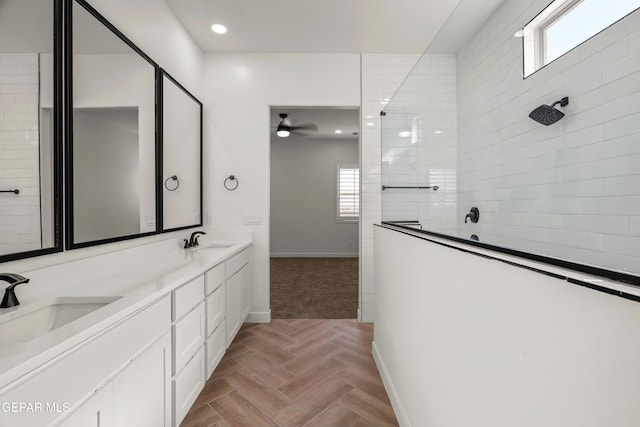 full bath with double vanity, a walk in shower, baseboards, and a sink