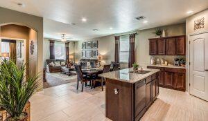 kitchen featuring dark brown cabinets, a center island, light countertops, dishwashing machine, and arched walkways