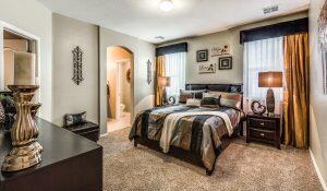 bedroom with multiple windows, arched walkways, and carpet floors