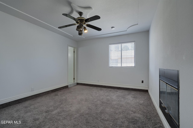 empty room with carpet flooring, ceiling fan, and baseboards