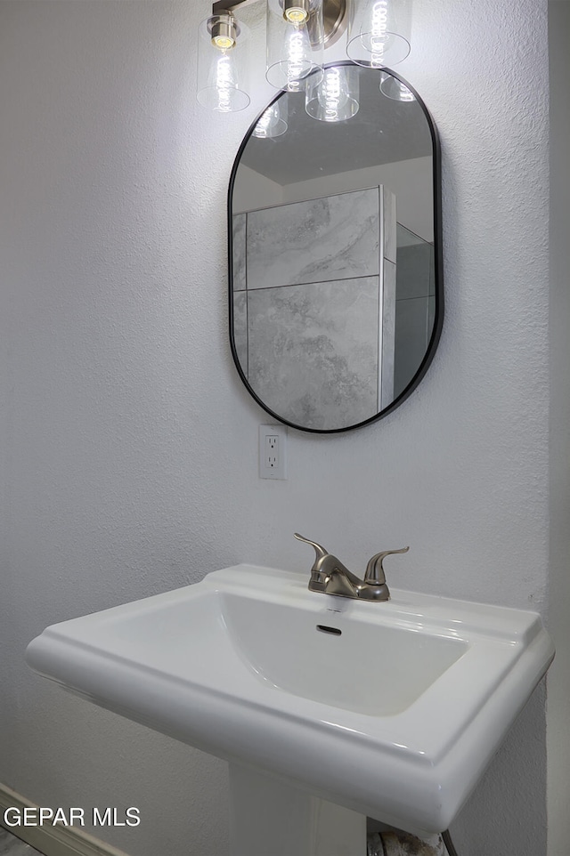 bathroom featuring a sink and a textured wall