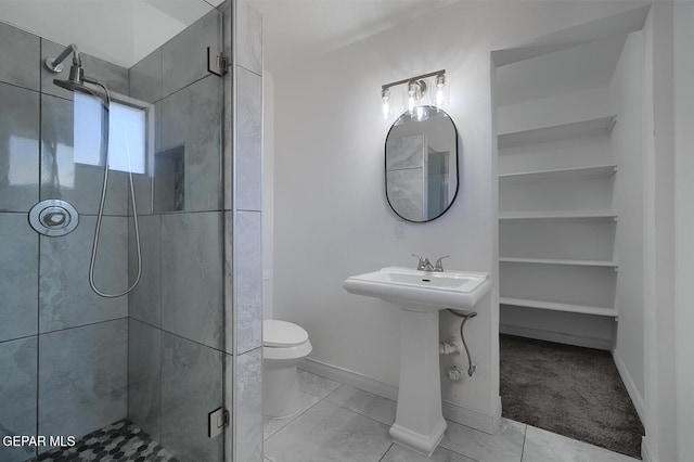 bathroom featuring a shower stall, toilet, baseboards, and tile patterned floors