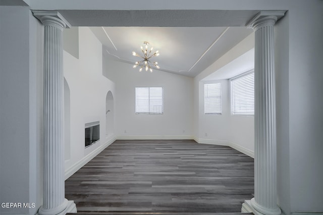 unfurnished living room featuring dark wood finished floors, vaulted ceiling, decorative columns, and plenty of natural light