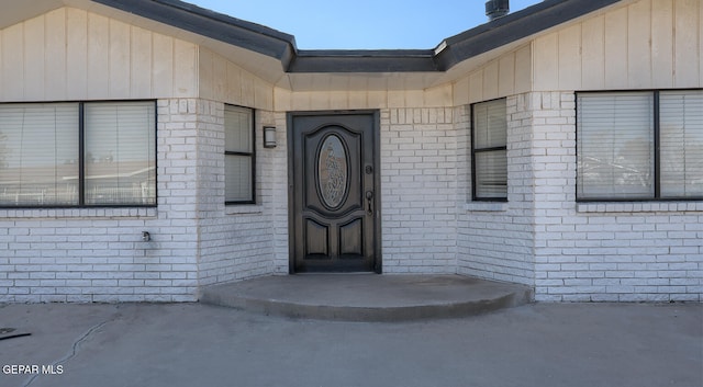 doorway to property featuring brick siding