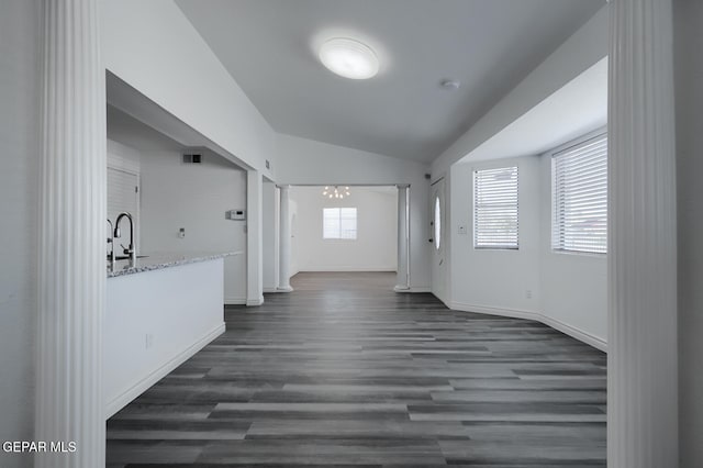 interior space featuring a wealth of natural light, visible vents, dark wood finished floors, and vaulted ceiling