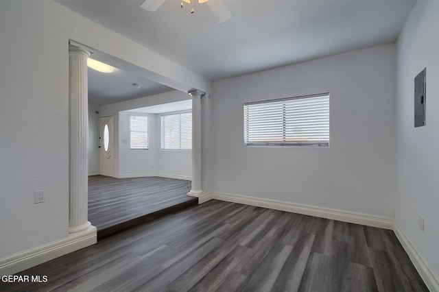 unfurnished room featuring baseboards, dark wood finished floors, decorative columns, electric panel, and a ceiling fan