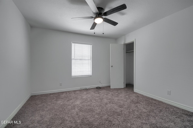 unfurnished bedroom with ceiling fan, a textured ceiling, baseboards, and carpet floors