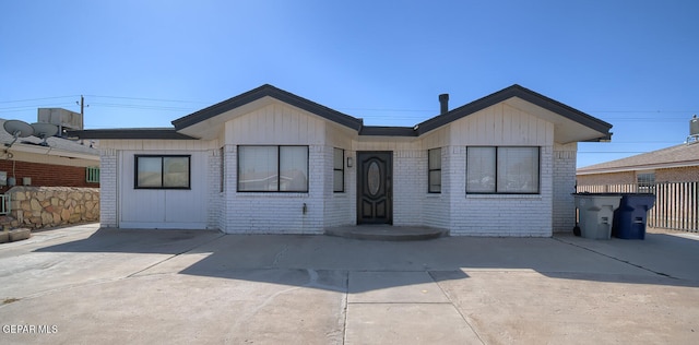 view of front of home featuring brick siding and fence